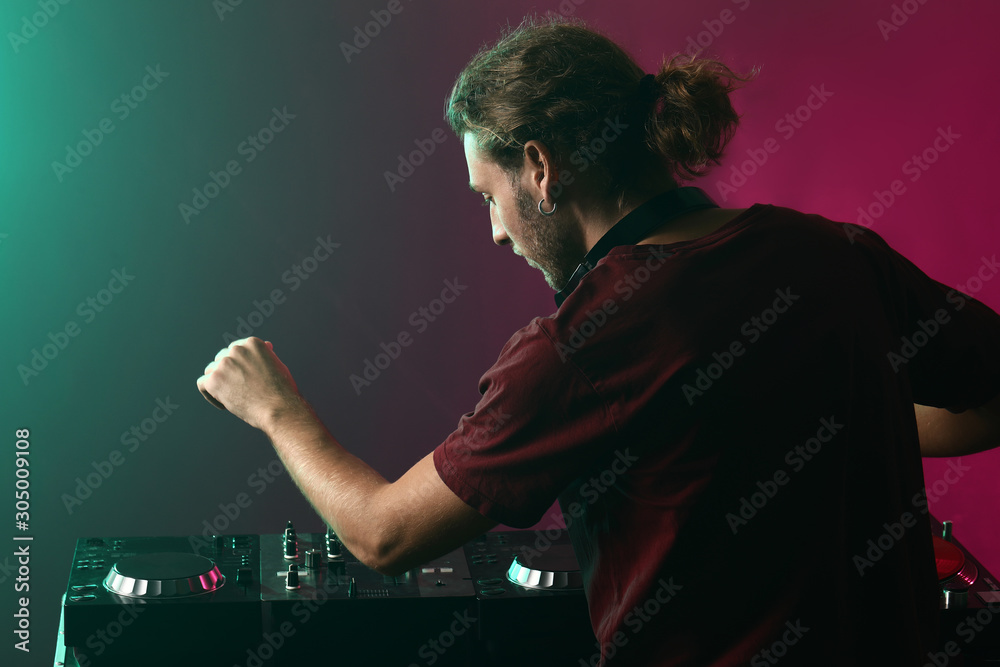 Male dj playing music in nightclub