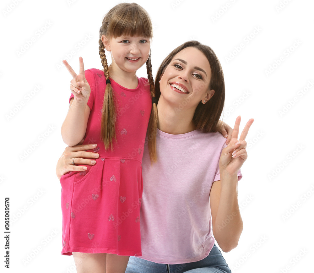 Portrait of happy mother and daughter showing victory gesture on white background