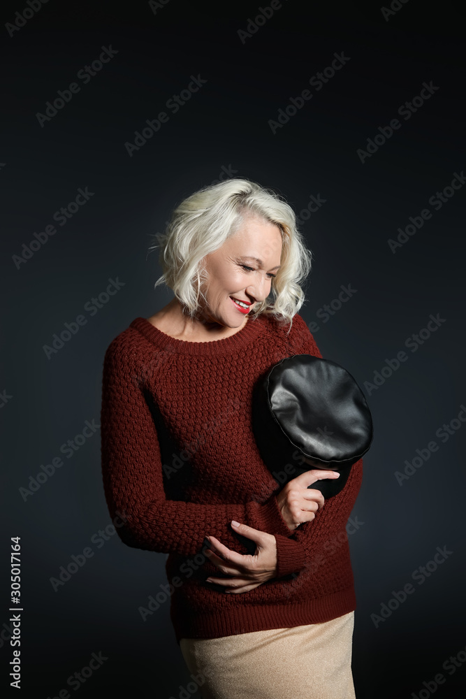 Portrait of stylish mature woman on dark background