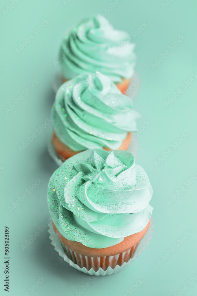 Tasty cupcakes on turquoise background