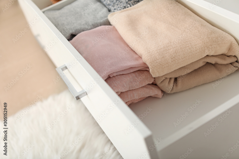 Drawer with stacked clean clothes in dressing room