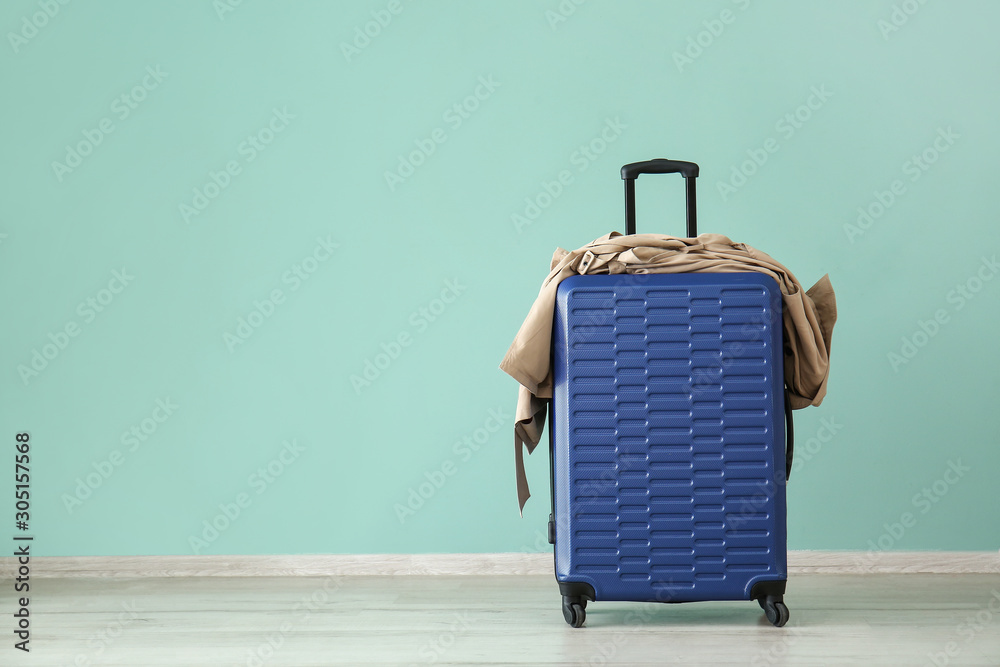 Suitcase near color wall. Travel concept