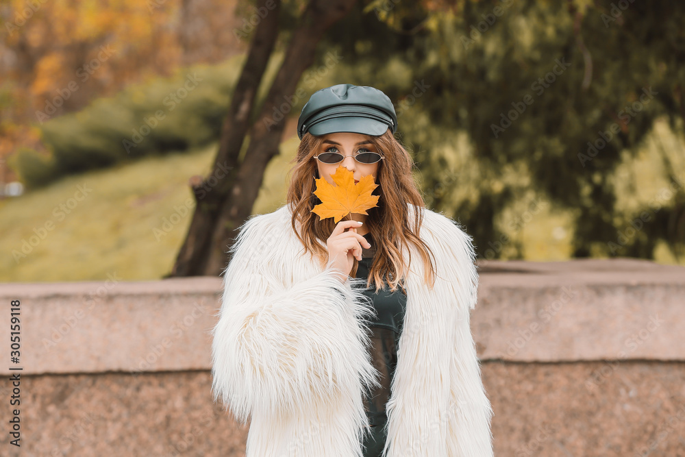 Portrait of stylish young woman in autumn park