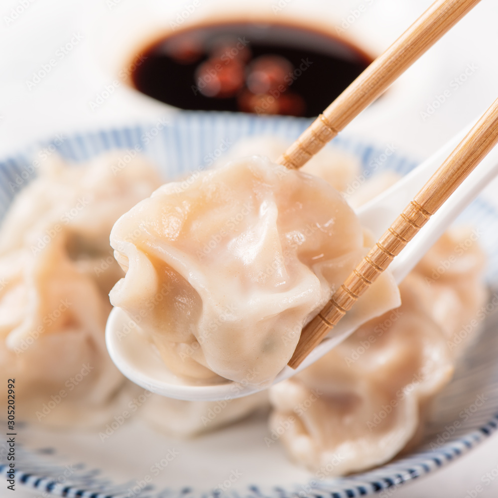 新鲜美味的水煮猪肉、白底虾饺子配酱油和筷子