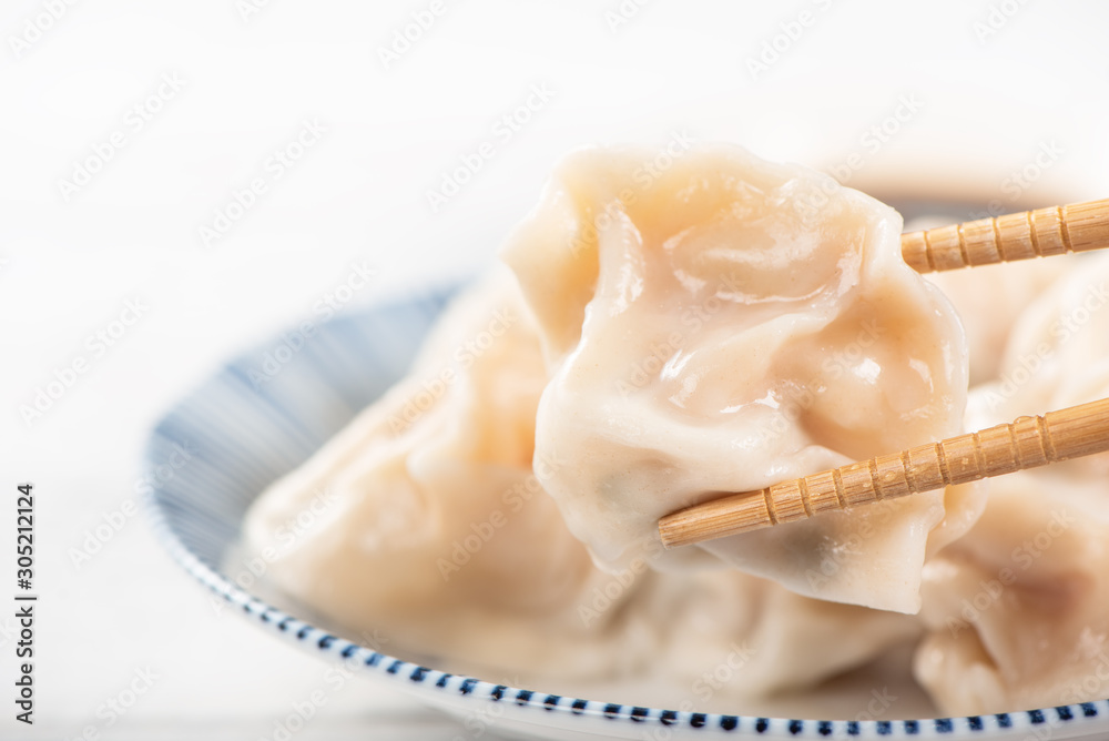 Fresh, delicious boiled pork, shrimp gyoza dumplings on white background with soy sauce and chopstic