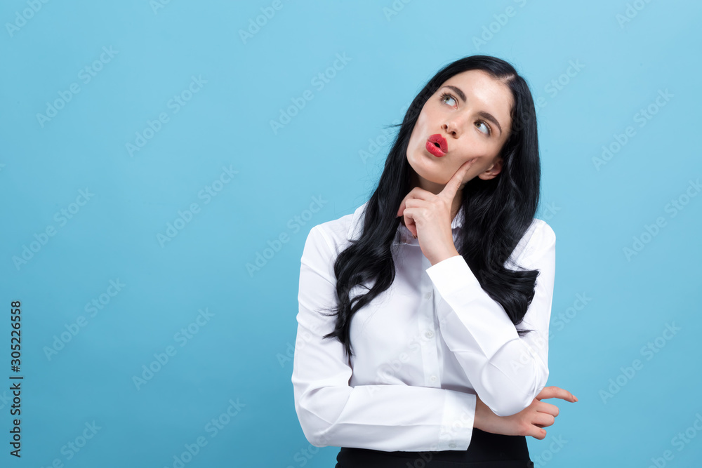 Young woman in a thoughtful pose on a blue background