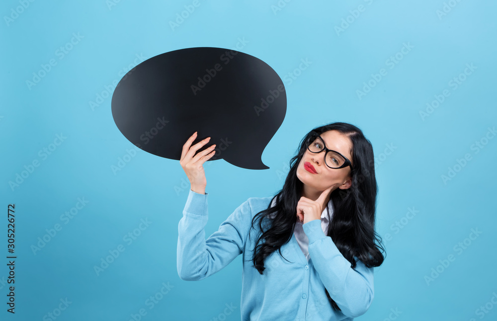 Young woman holding a speech bubble on a blue background