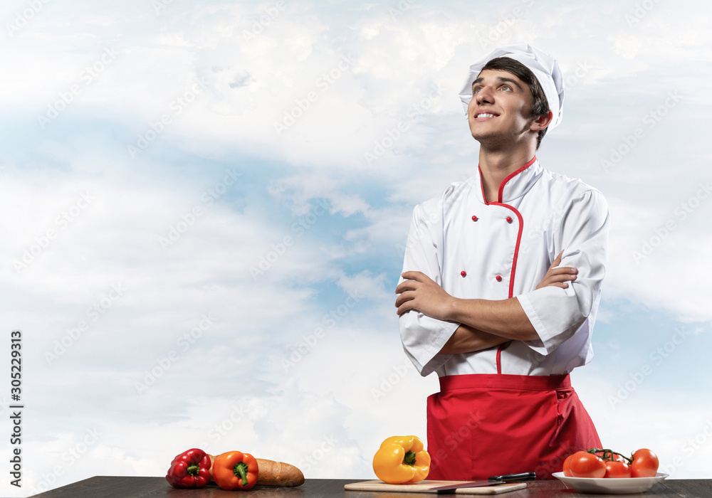 Young male chef standing with folded arms