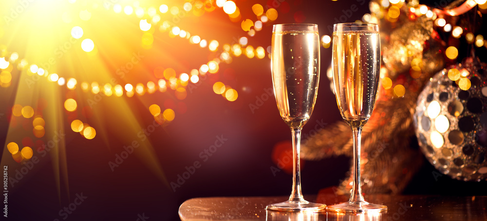 Holiday Champagne Flute over Golden glow background. Christmas and New Year celebration. Two Flutes 