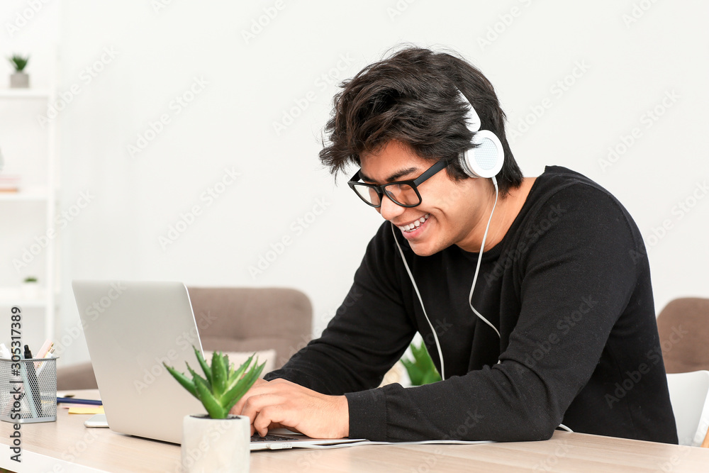 Asian programmer working on laptop in office