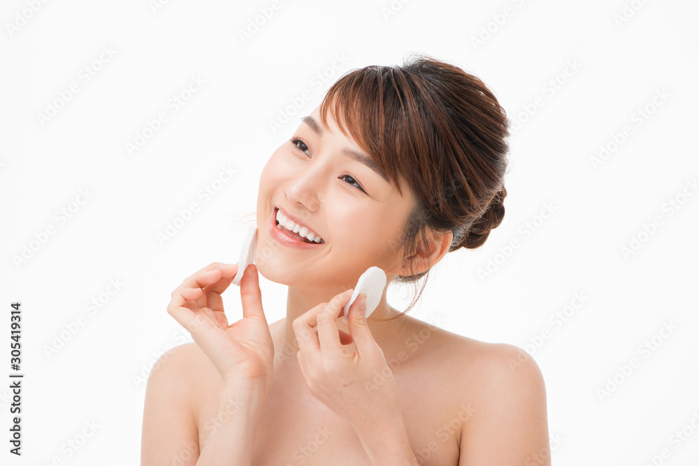 Asian woman with fair perfect healthy glow skin hands hold cotton pad cleansing face isolated on whi