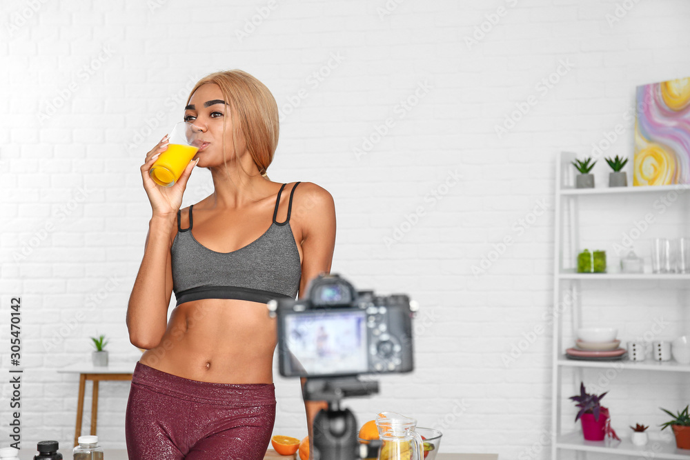 African-American blogger recording video about sport and healthy food at home