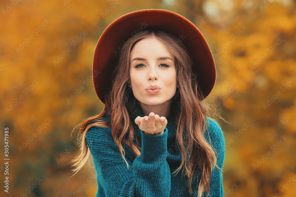 Portrait of stylish young woman in autumn park