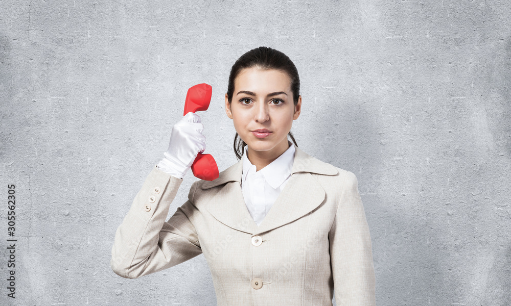 Beautiful business woman with vintage red phone