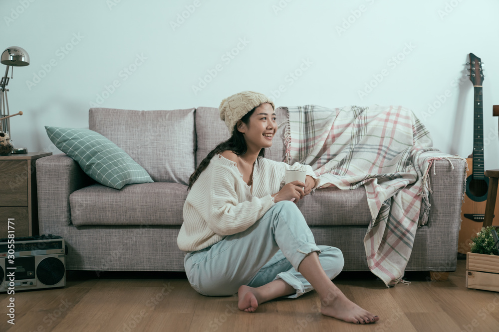 blank happy woman drink coffee in early winter morning. young asian girl sitting on wooden floor in 