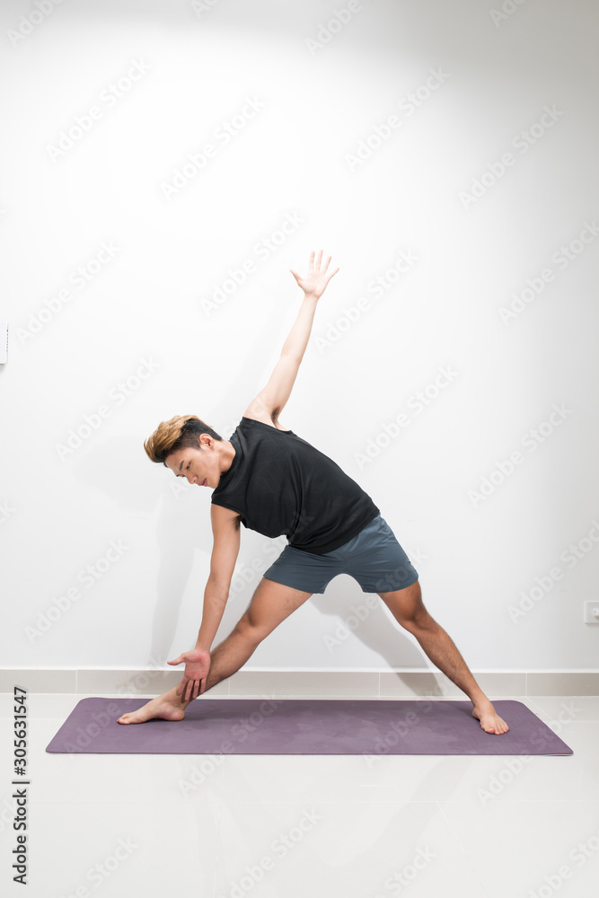 A man doing yoga exercises. Studio shot over white background.