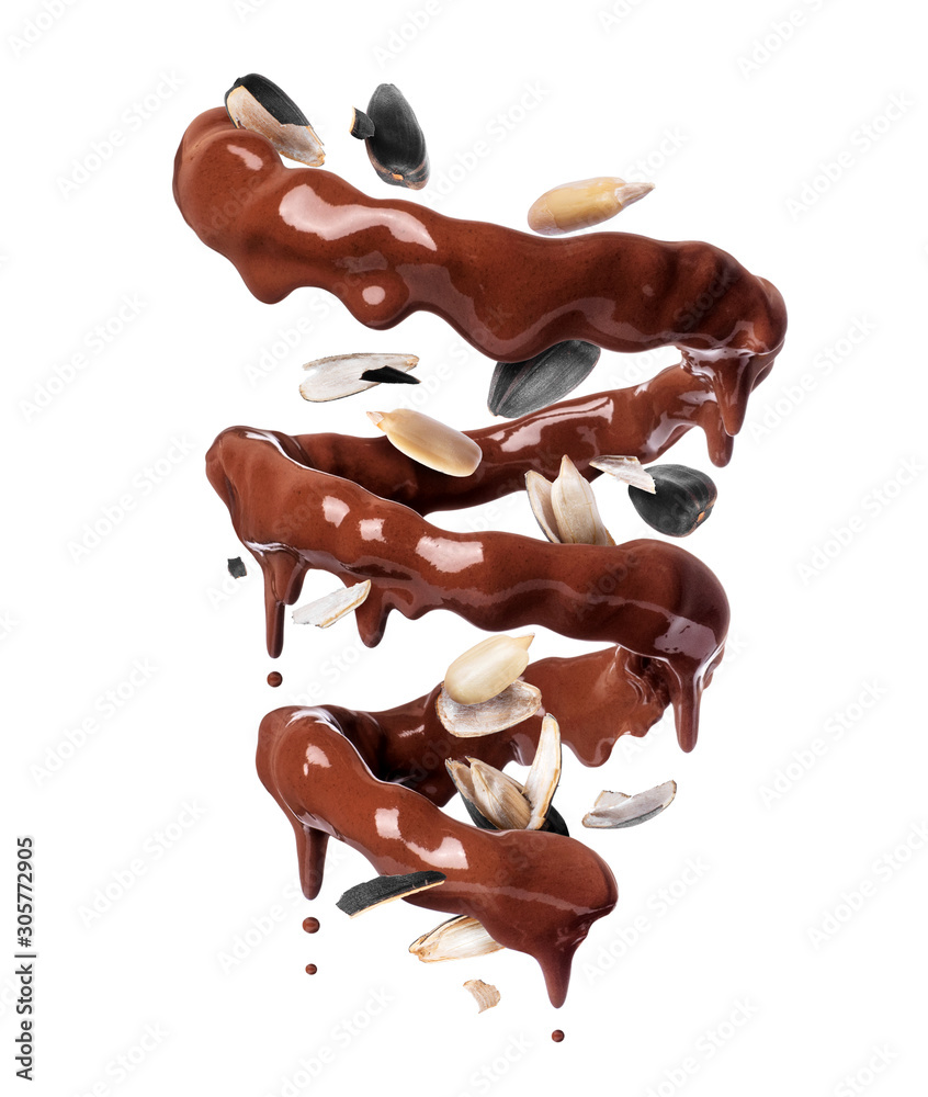 Chocolate splashes in spiral shape with crushed sunflower seeds, isolated on a white background