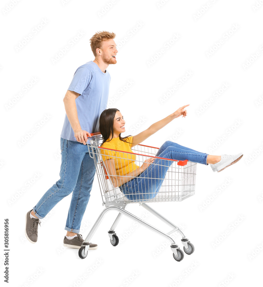 Young couple with shopping cart on white background