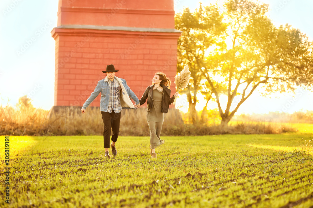 Happy young couple running in countryside