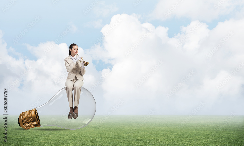 Business woman sitting on big light bulb