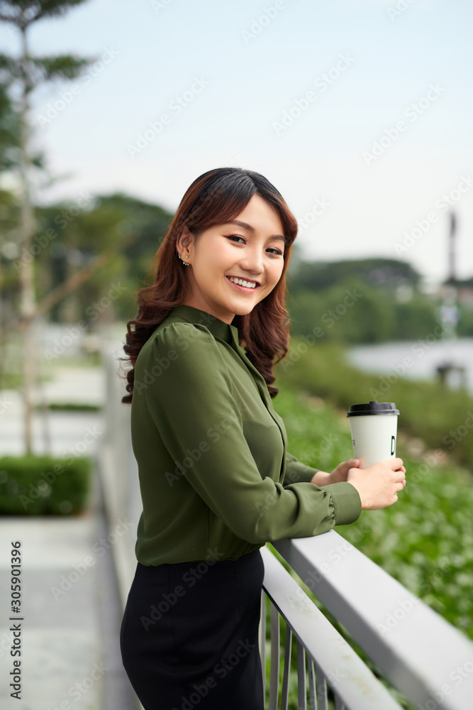 漂亮女人在公园里享受热饮