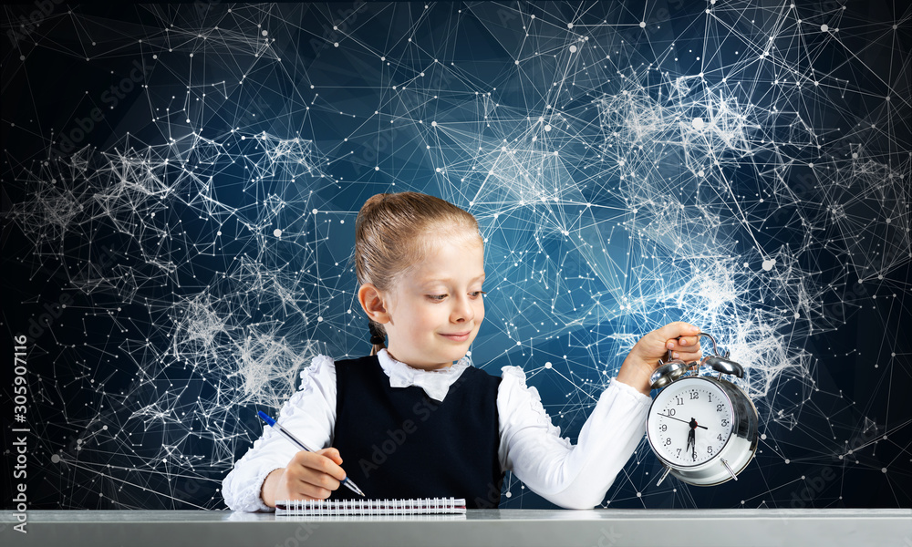 Smiling little girl holding alarm clock