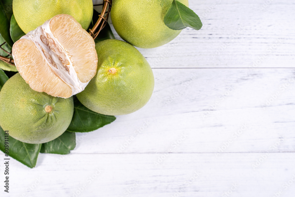 Fresh peeled pomelo, pummelo, grapefruit, shaddock on bright wooden background. Autumn seasonal frui