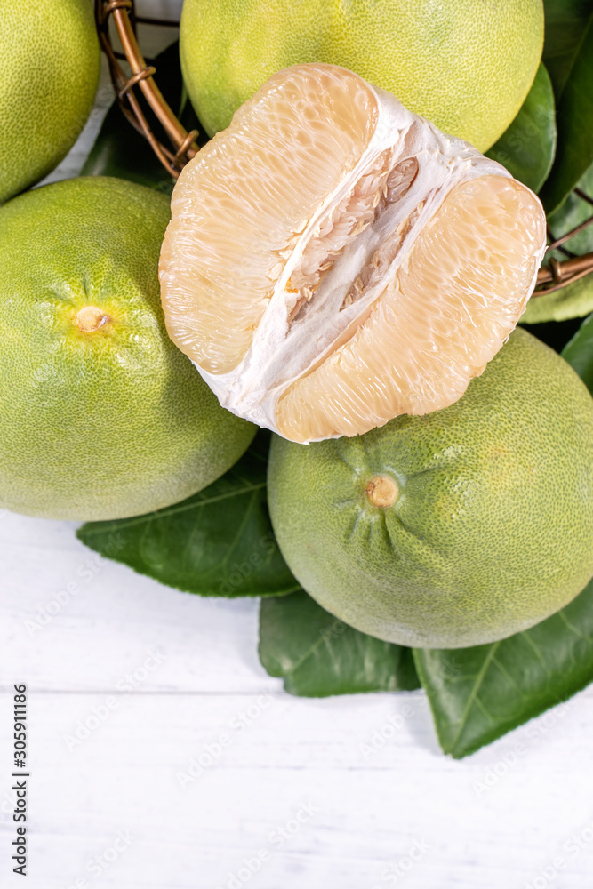 Fresh peeled pomelo, pummelo, grapefruit, shaddock on bright wooden background. Autumn seasonal frui