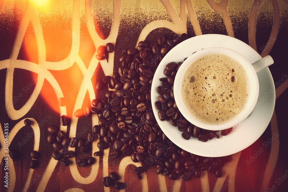 Cup of coffee and scattered coffee beans on background