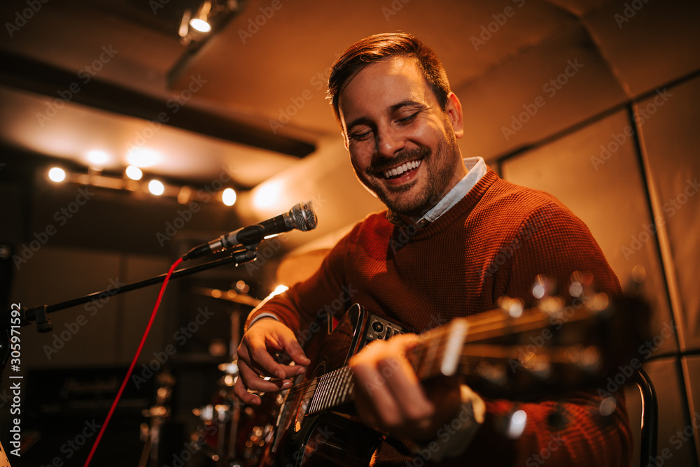 Happy man playing with a guitar, portrait, close-up.