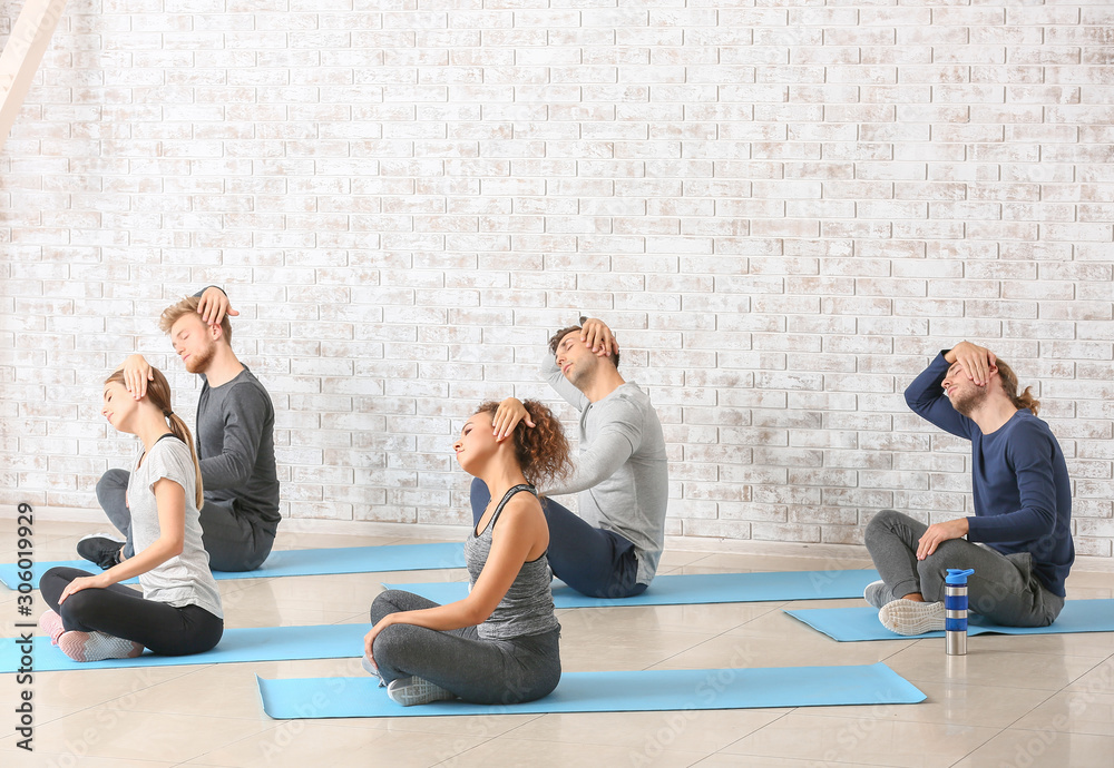 Group of people practicing yoga in gym