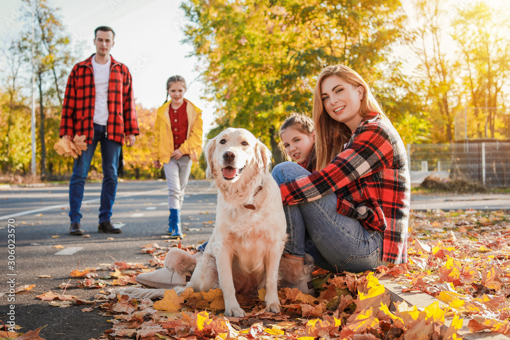 Happy family with dog resting in autumn park