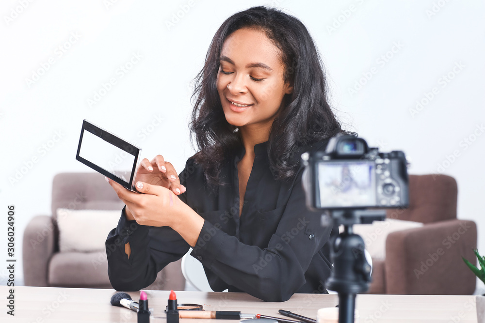 Young African-American beauty blogger recording video at home