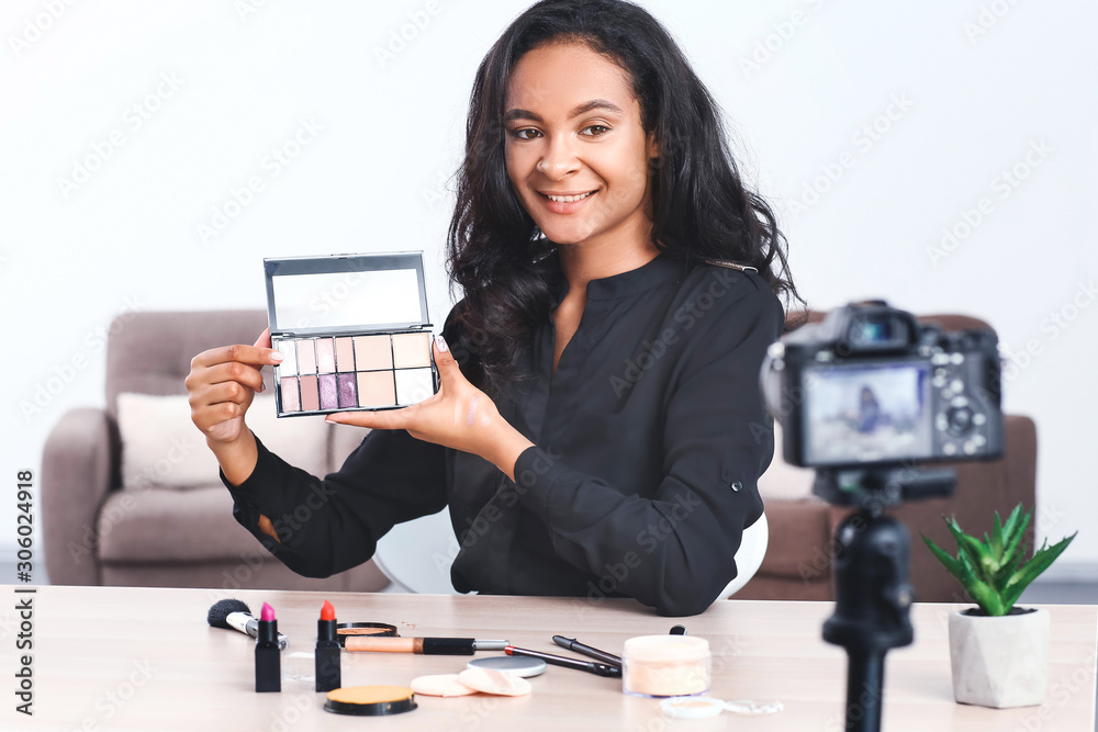 Young African-American beauty blogger recording video at home