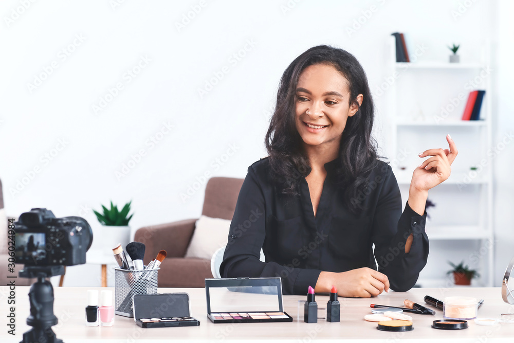 Young African-American beauty blogger recording video at home