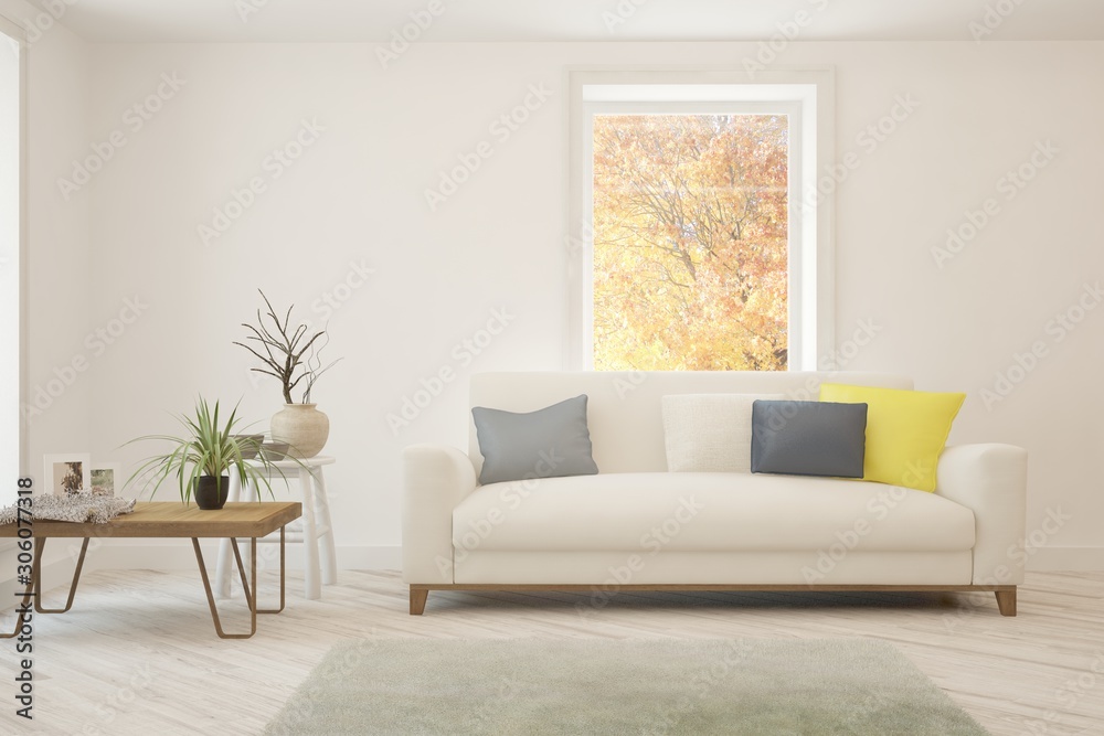 Stylish room in white color with sofa and autumn landscape in window. Scandinavian interior design. 