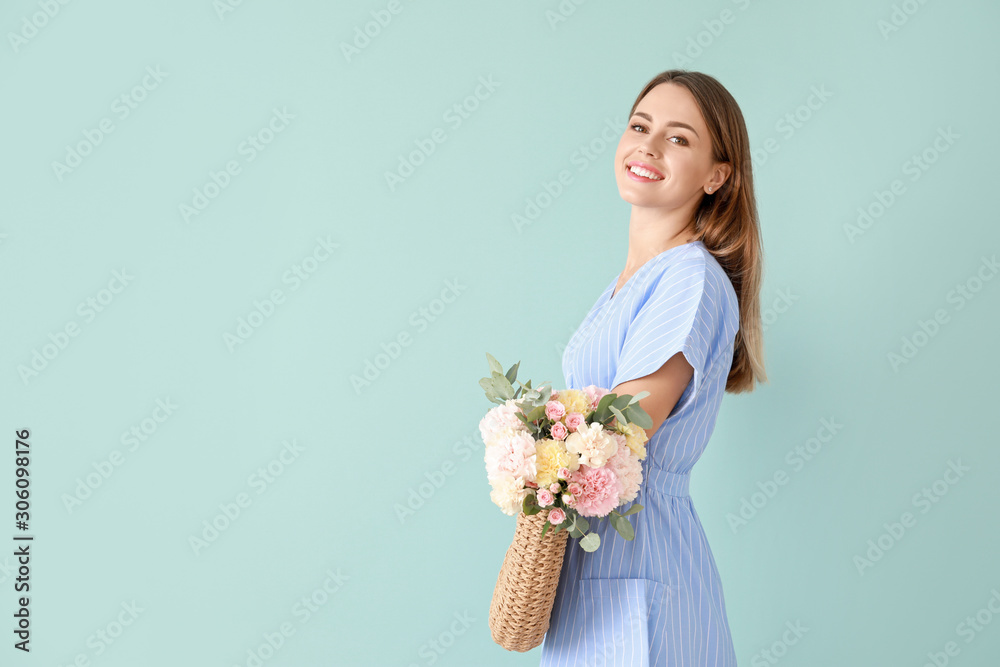 Beautiful young woman with bag and bouquet of carnation flowers on color background