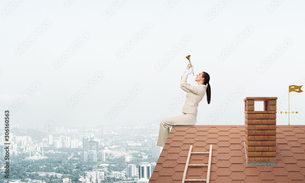 美丽的年轻女子在屋顶上吹小号