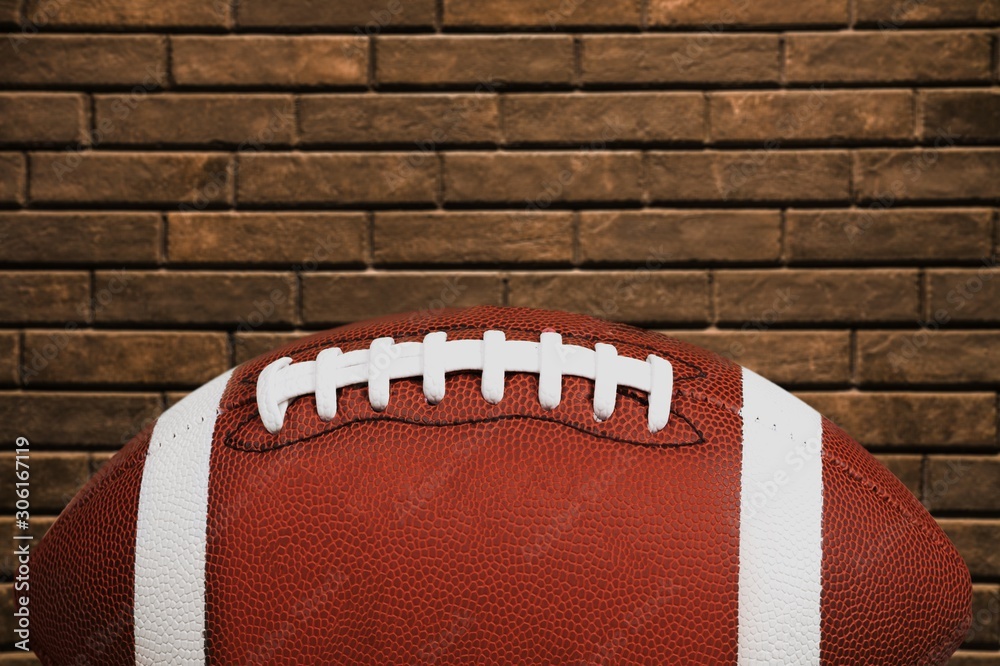 American football ball on a stone field background