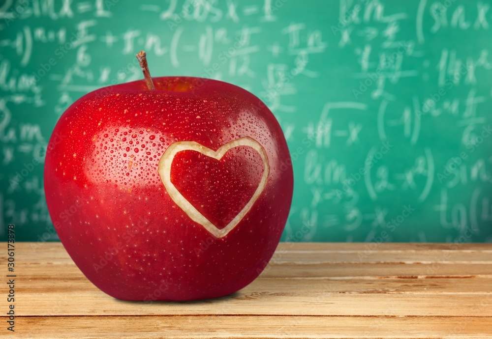 Photo of red apple with heart on the school desk