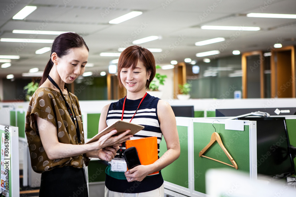 タブレットで資料を共有する女性マネージャーたち