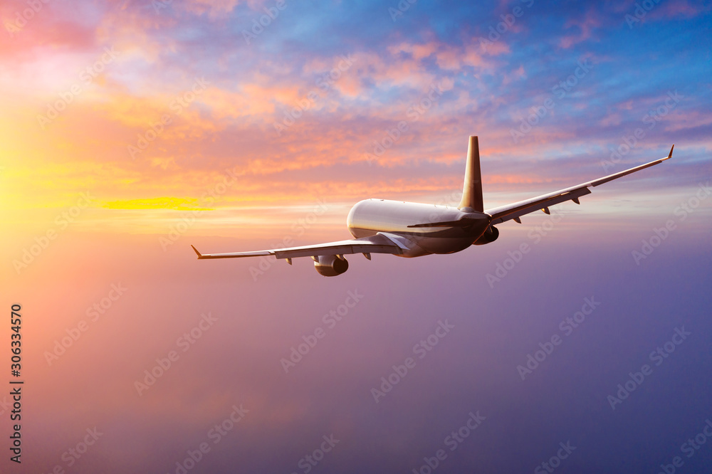 Passengers commercial airplane flying above clouds in sunset light. Concept of fast travel, holidays