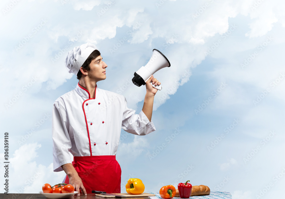 Young chef standing with megaphone in hand