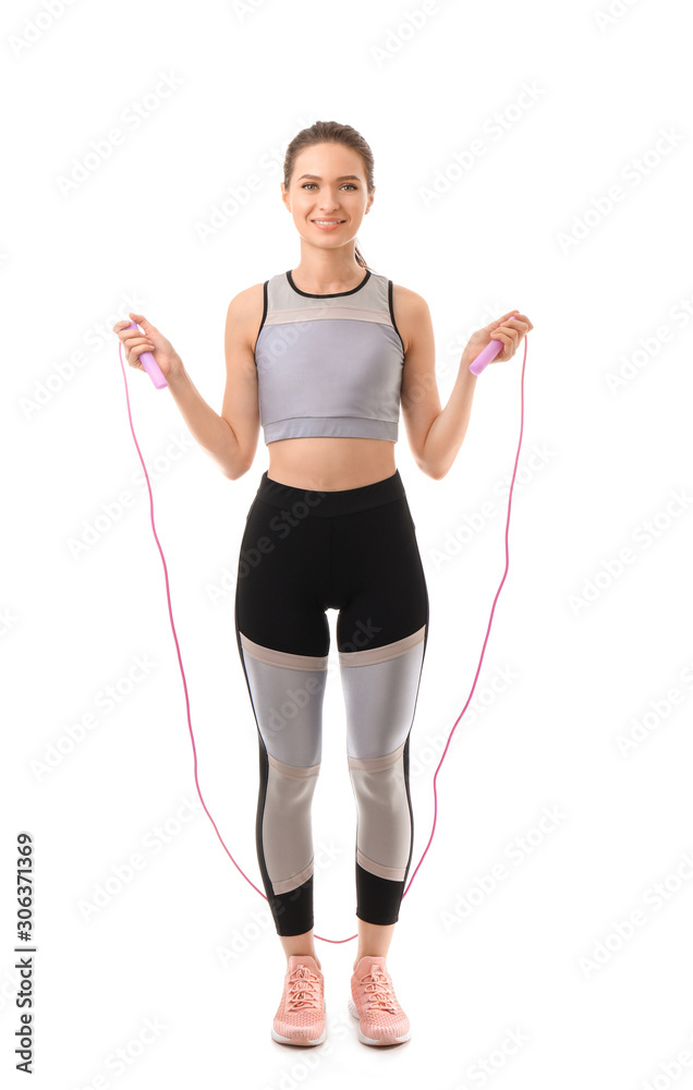 Sporty young woman with jumping rope on white background