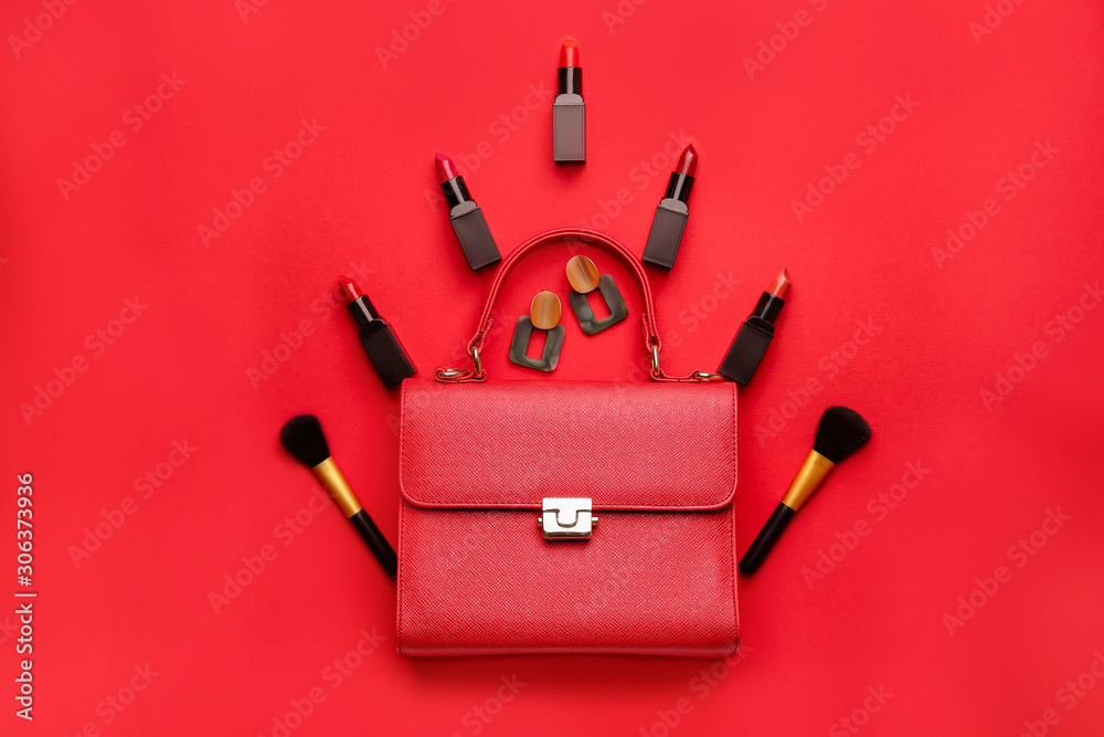 Beautiful Christmas tree made of lipsticks, brushes and earrings and bag on color background