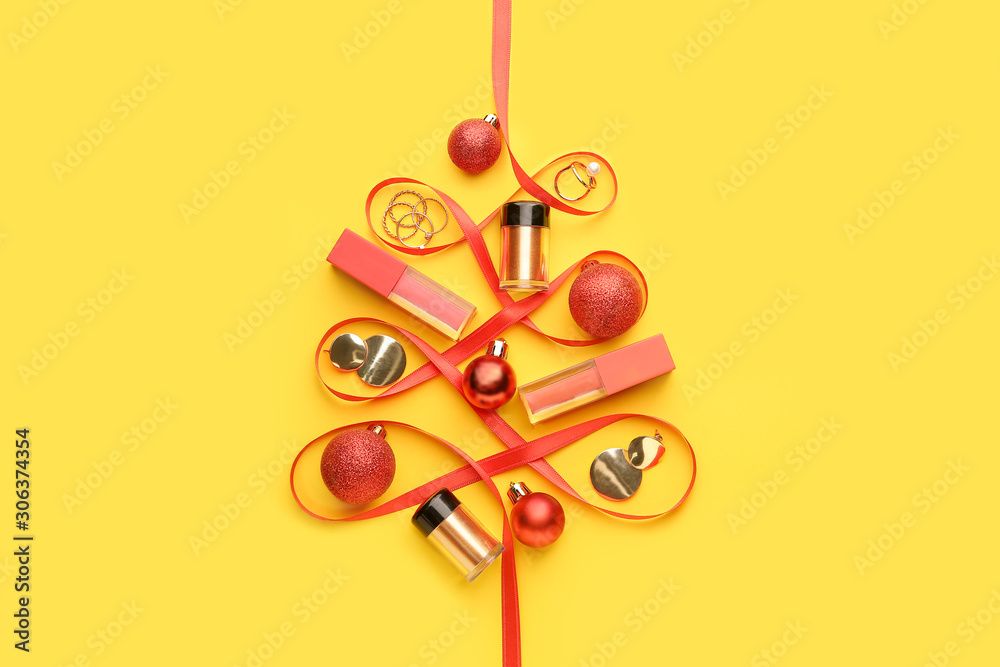 Beautiful Christmas tree made of makeup cosmetics, jewelry and ribbon on color background