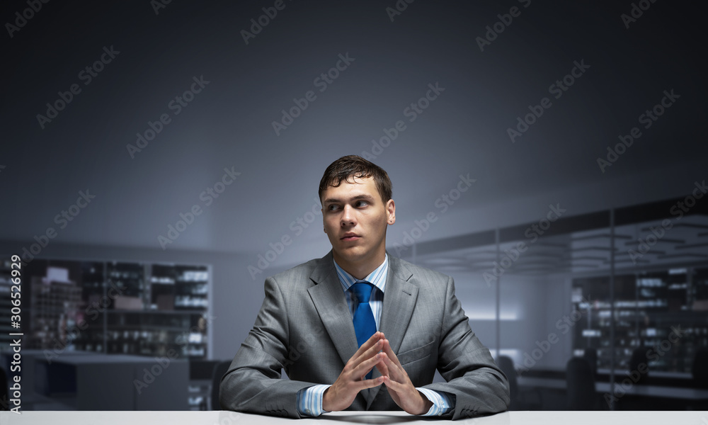 Young man folded hands and having serious face