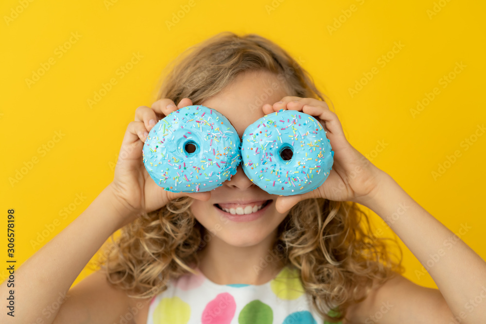 Happy child holding glazed donut