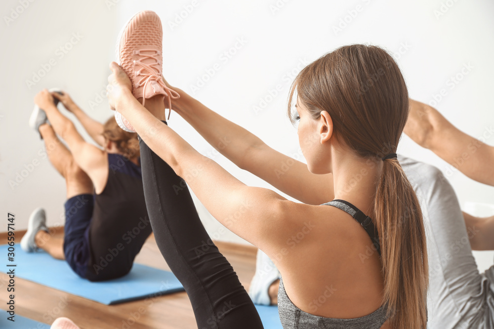 Group of people practicing yoga in gym