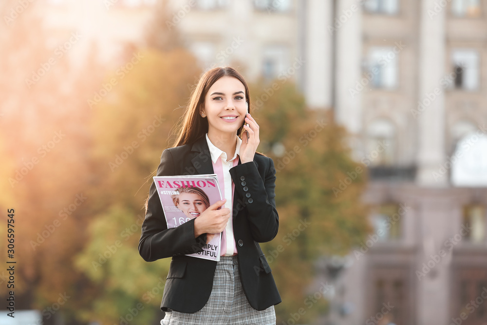 Beautiful young businesswoman talking by phone outdoors